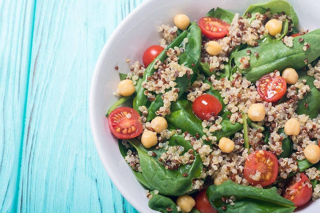 Foto insalata di spinaci con pomodori di quinoa e ceci superalimento vegano sano