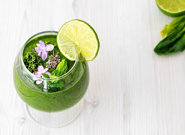 Spinach smoothie with fruits and seeds, decorated with mint leaves