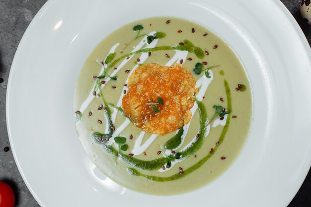 Spinach soup with croutons in white bowl