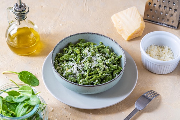 Photo spinach spatzle or green spatzle are the typical tyrolean green dumplings or gnocchi on plate with grated cheese and olive oil