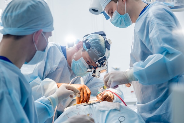 Photo spinal surgery. group of surgeons in operating room with surgery equipment. laminectomy