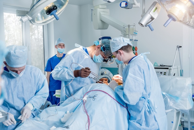 Spinale chirurgie. Groep van chirurgen in operatiekamer met chirurgische apparatuur. Laminectomie