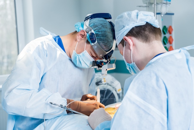 Spinale chirurgie. Groep van chirurgen in operatiekamer met chirurgische apparatuur.