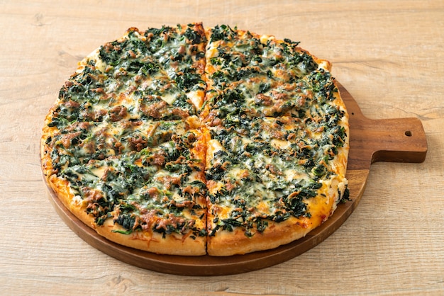 spinazie en kaas pizza op houten dienblad - veganistische en vegetarische eetstijl