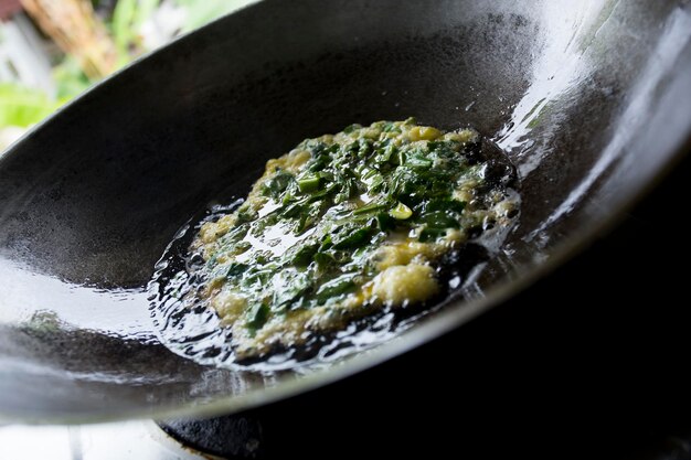 Spinazie-omelet gekookt in een zwarte koekenpan