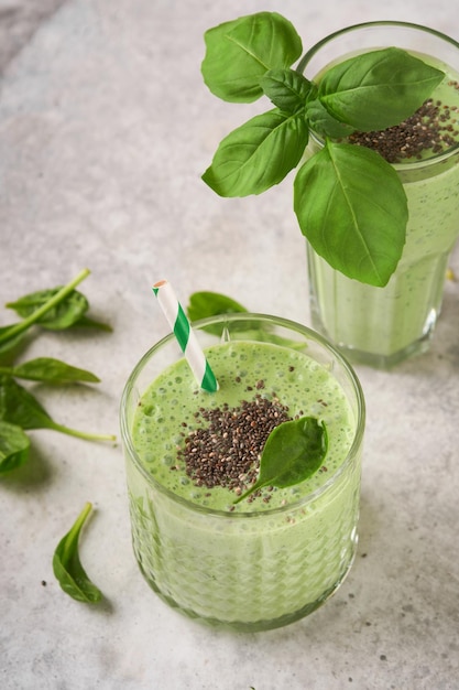 Spinazie smoothie gezond groen Vegan smoothie of milkshake van spinazie banaan en chia zaden op grijze betonnen tafel achtergrond Schoon eten alkalisch dieet Bovenaanzicht Mock up