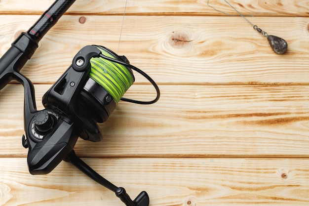 Spinning for fishing on wooden background close up