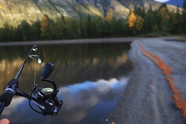 spinning reel in hand fishing nature, abstract background, hobby vacation man