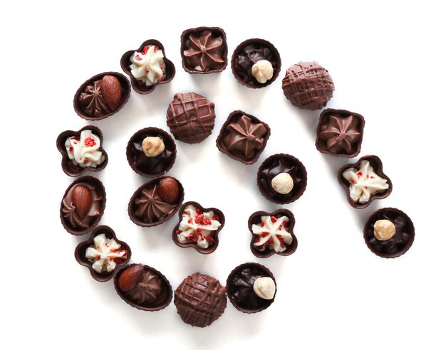 Spiraalvormige samenstelling van chocoladesuikergoed op witte achtergrond