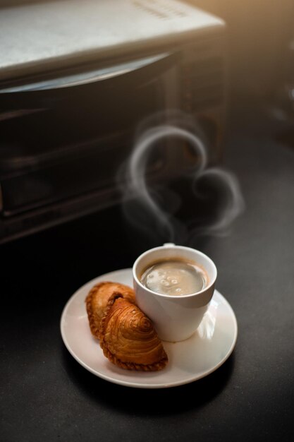 Spiral curry puff and black coffee on a white plate