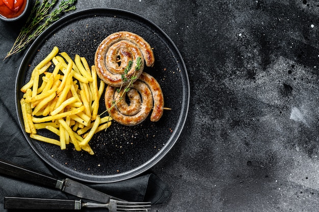 Spiral grilled sausages with a side dish of French fries