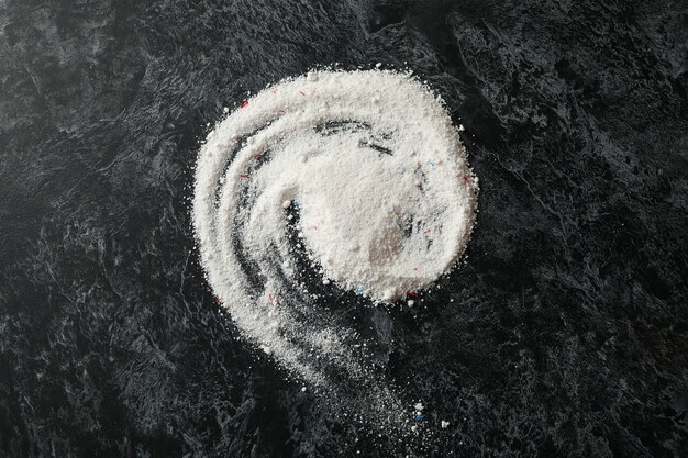 Foto spirale di detersivo in polvere sul tavolo smokey nero