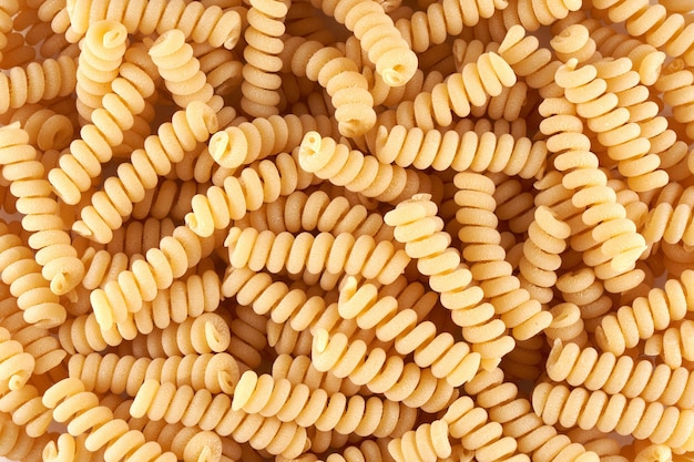 Spiral noodles close up background, pasta and macaroni