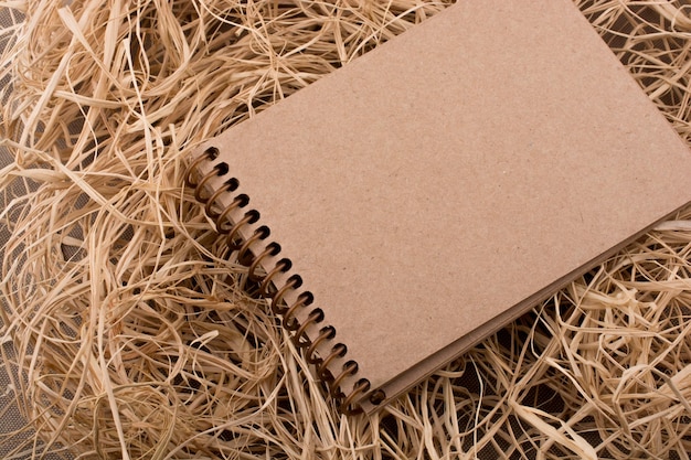 Spiral notebook placed on straw background