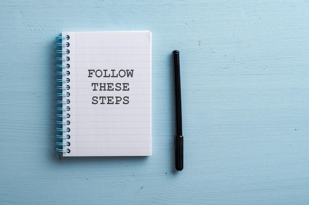 Spiral notebook with a Follow these steps sign