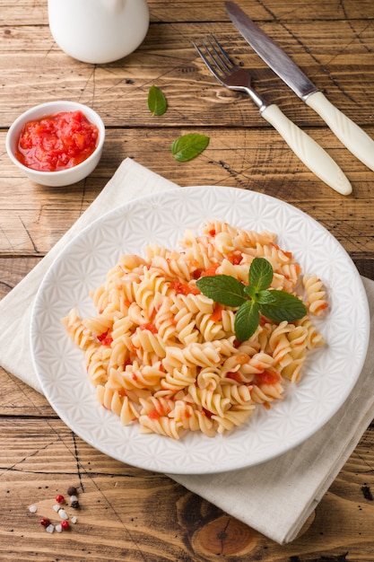 Spiral pasta mixed with cherry tomatoes and tomato sauce on a plate.