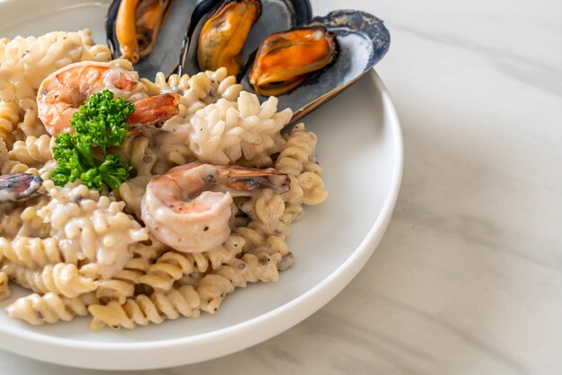 Salsa di crema di funghi pasta spirale con frutti di mare - stile di cibo italiano