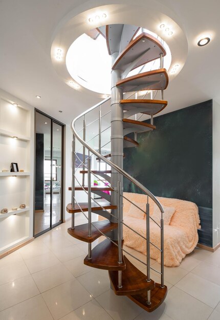 Spiral staircase to second floor in hall of modern luxury apartment Private house