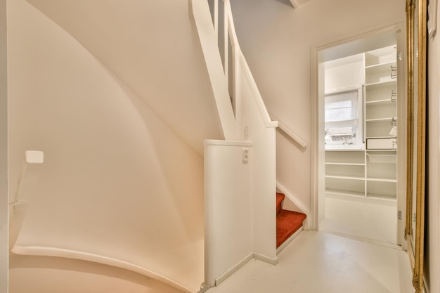 Винтовая лестница белого цвета с ковровыми ступенями в современном доме