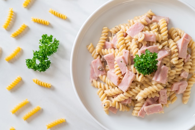 Photo spirali or spiral pasta mushroom cream sauce with ham - italian food style