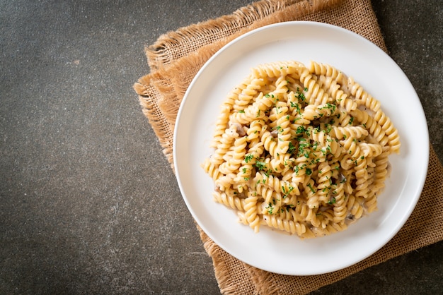 Foto salsa di crema di funghi spirali o spirale con prezzemolo - stile alimentare italiano