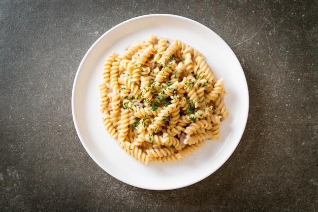 Spirali o pasta a spirale salsa di crema di funghi con prezzemolo, stile alimentare italiano