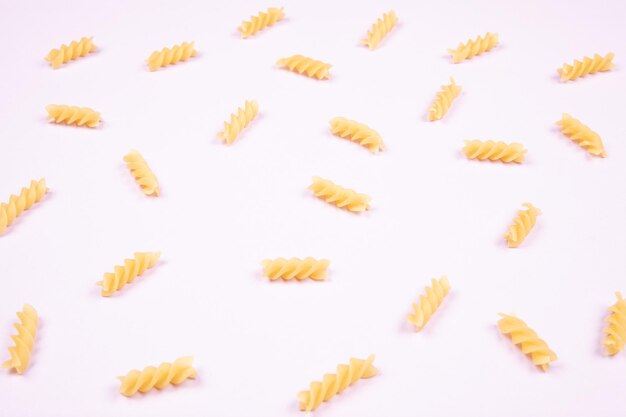 Spirals dried pasta on a light purple isolated background