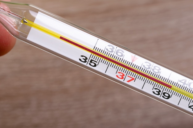 Spirit or mercury thermometer with a high temperature indicator after measurement. Close-up.