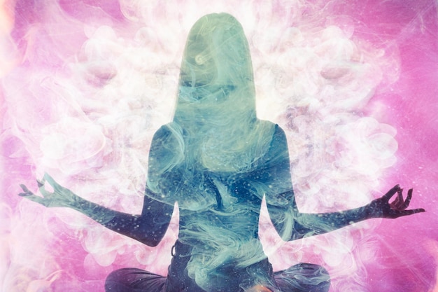 Foto pratica spirituale armonia equilibrio silhouette di donna meditante in doppia esposizione di fumo etereo rosa