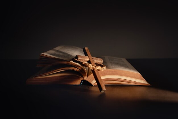 Photo spirituality, religion and hope concept. holy bible and cross on desk. symbol of humility, supplication,believe and faith for christian people