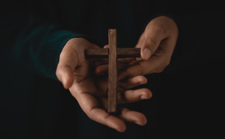 Spirituality Religion and Hope Concept Person with Wooden Cross on Hands Symbol of Humility Supplication Believe and Faith for Christian People Dark Tone Cropped and Selective focus