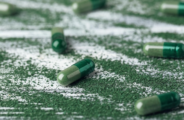 Photo spirulina capsules with powder on table