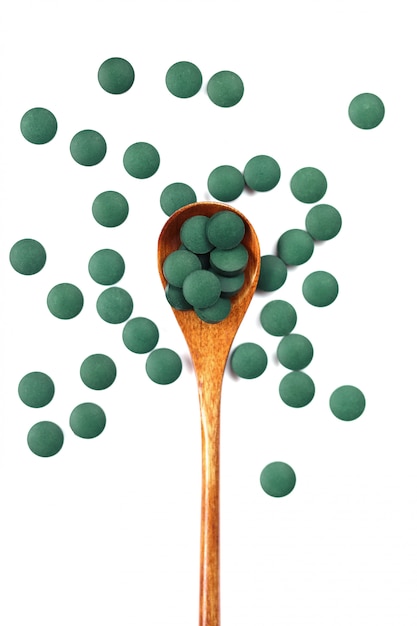 Spirulina. Houten lepel met spirulina-tabletten