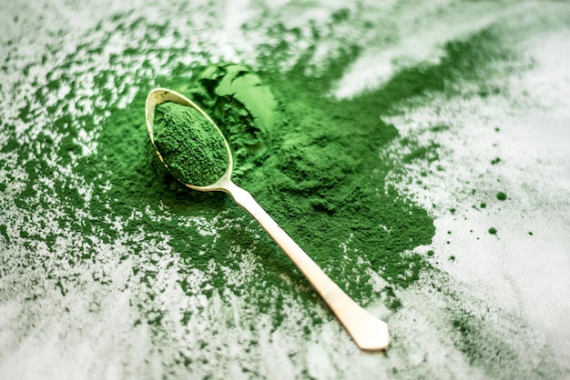 spirulina poeder verspreid op een betonnen ondergrond