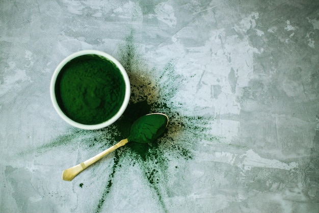 spirulina powder scattered on a concrete background