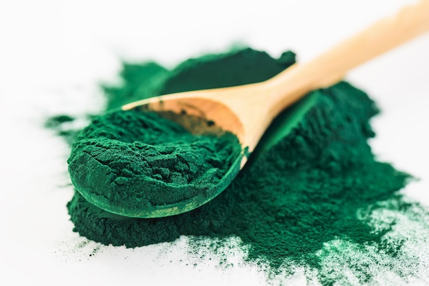 Spirulina powder in a wooden spoon