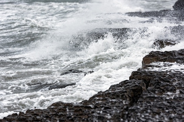 Splash of big waves on a rocky seashore landscape