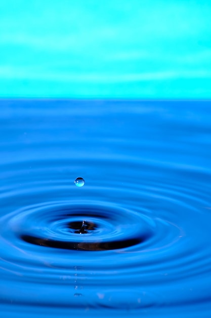 青の背景に発散水円と水のスプラッシュ ドロップ