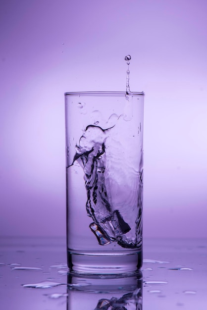 Splash of falling ice in a glass with water