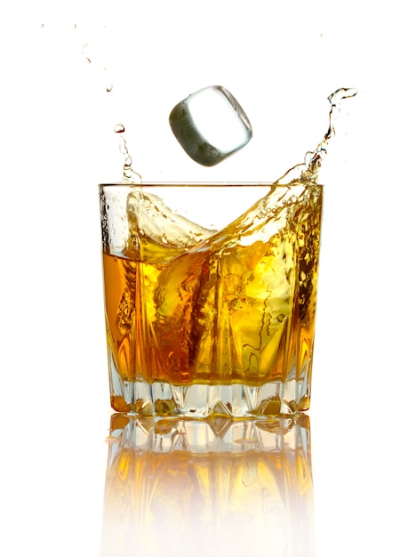 Splash in glass of whiskey and ice isolated