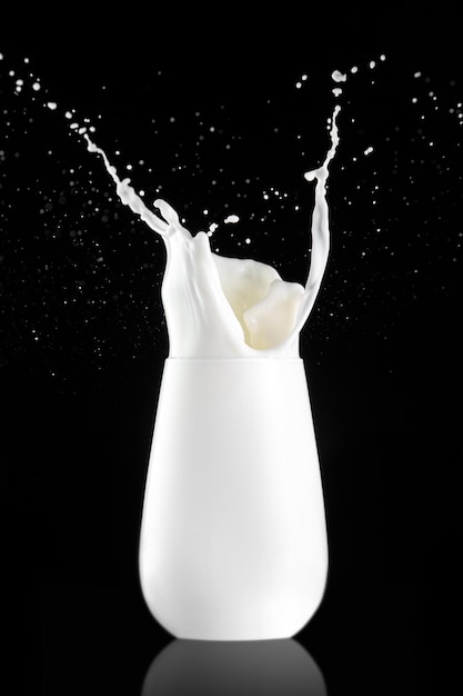 Splash in a glass with milk isolated on black background