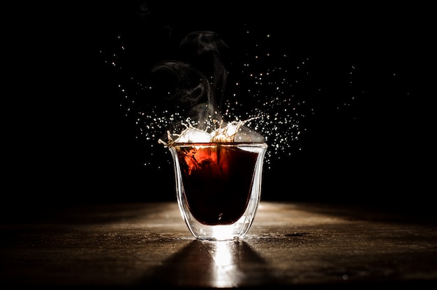 Splash of the hot coffee from the transparent glass