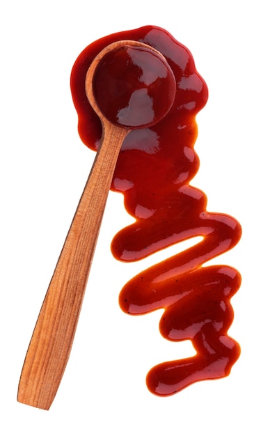 Splash of ketchup sauce with wooden spoon isolated on white background Top view