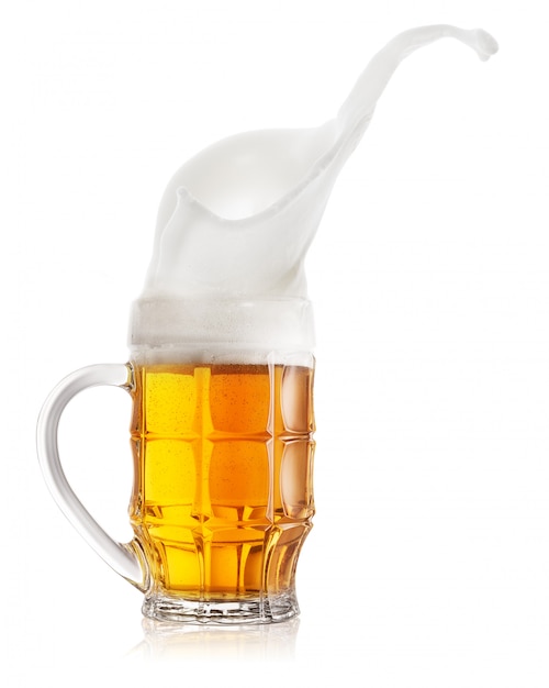 Splash of light beer in faceted mug