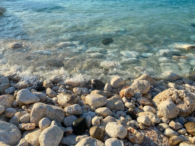 Splash of sea water and foam on the stone shore