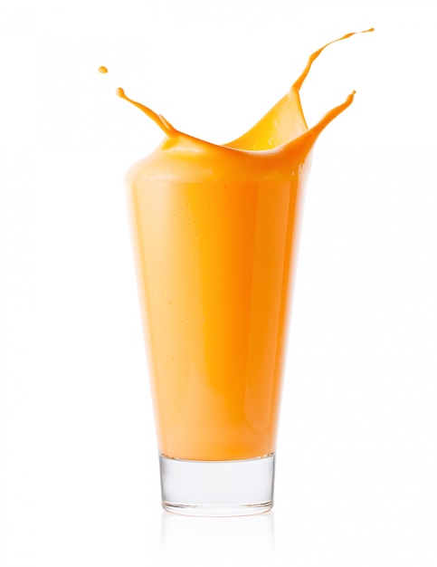 Splash in tall glass of carrot or orange smoothie or yogurt