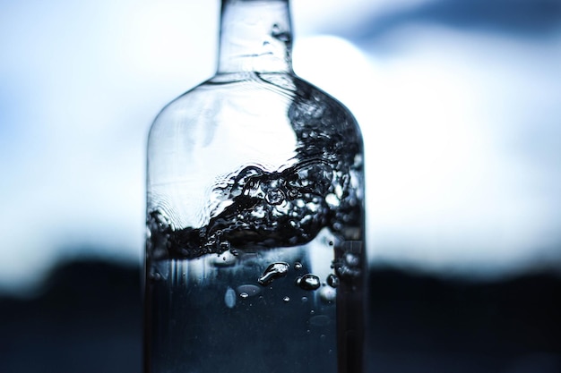 a splash of water in a bottle closeup on a dark light background water details water structure