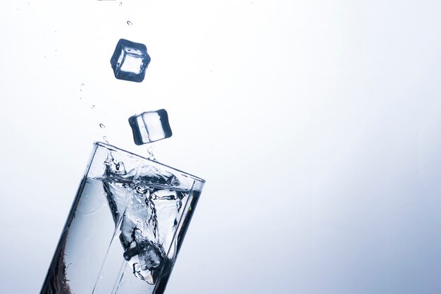 A splash of water in a glass from an ice cube . The