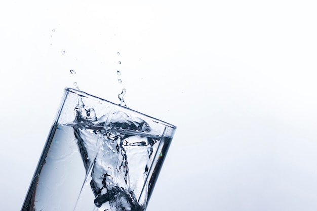 A splash of water in a glass from an ice cube .