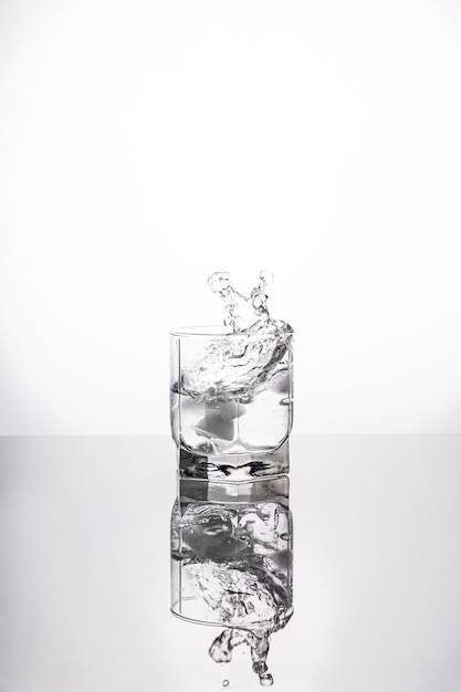 A splash of water in a glass on a light background fresh water glass with bubbles white background